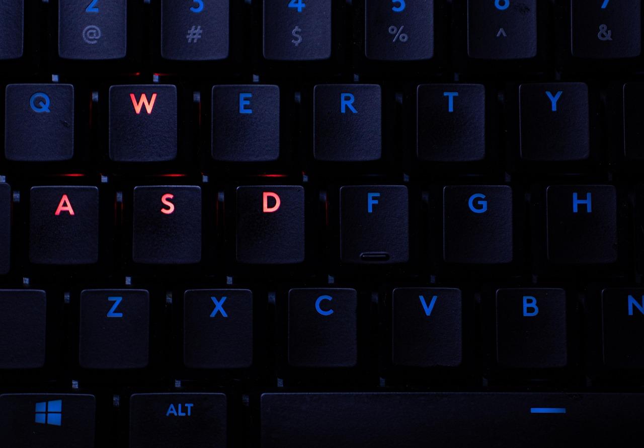 Teclado mecánico gaming con iluminación RGB resaltando las teclas WASD, representando la gestión de periféricos de entrada a través de DirectInput.