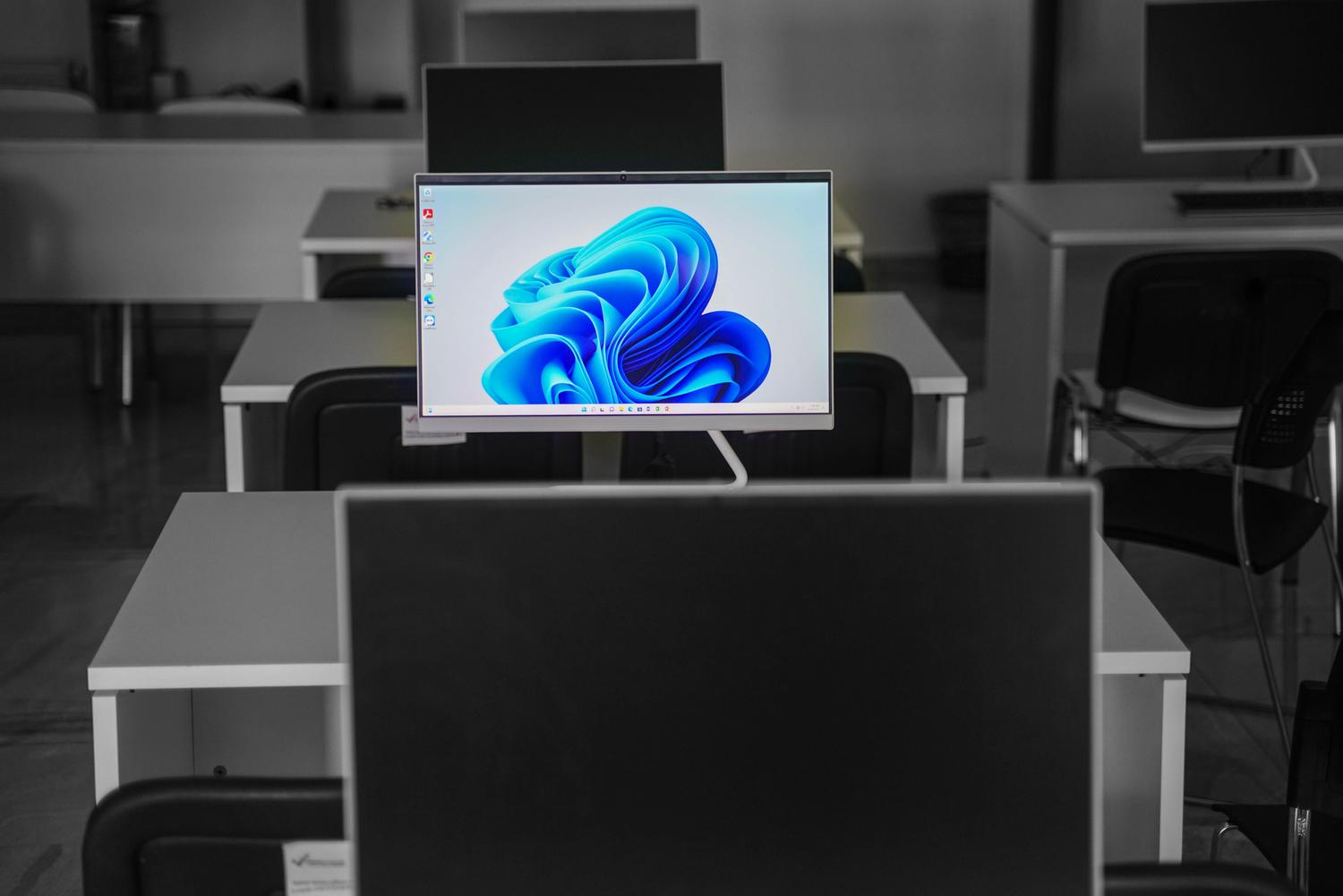 Oficina moderna y minimalista con un monitor brillante y vibrante, resaltando la luminosidad y la claridad de la tecnología Mini-LED.