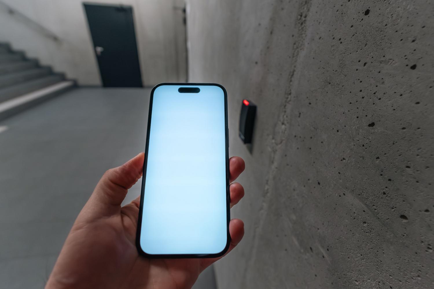 Smartphone desbloqueando una puerta de seguridad mediante tecnología NFC en un edificio moderno