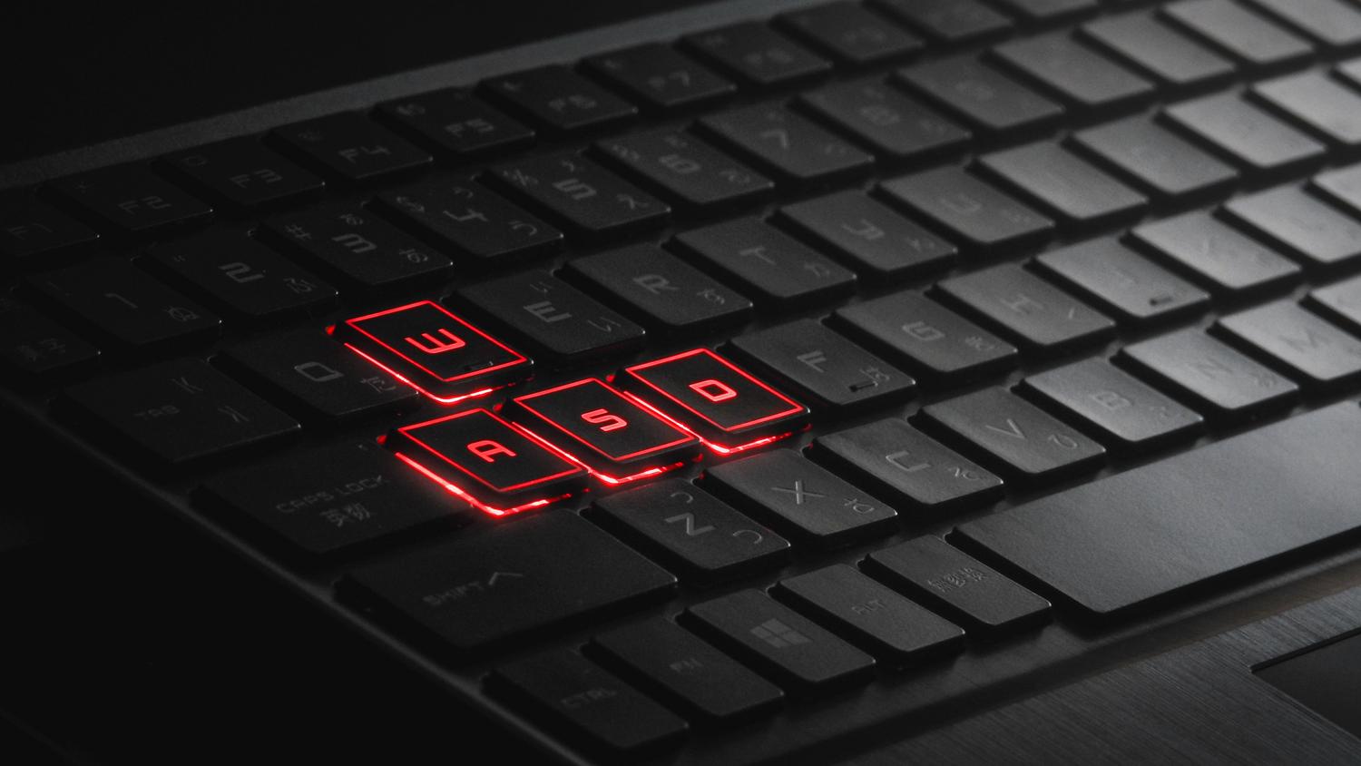 Primer plano de las teclas iluminadas de un teclado gaming, ideal para ilustrar la sección de controles y teclas de dirección del juego.