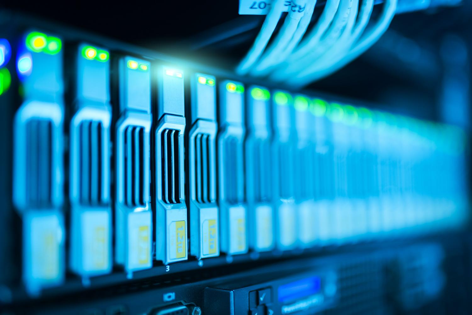 Infraestructura de centro de datos con bahías de almacenamiento de servidores y luces LED, representando el almacenamiento físico de bases de datos IoT.