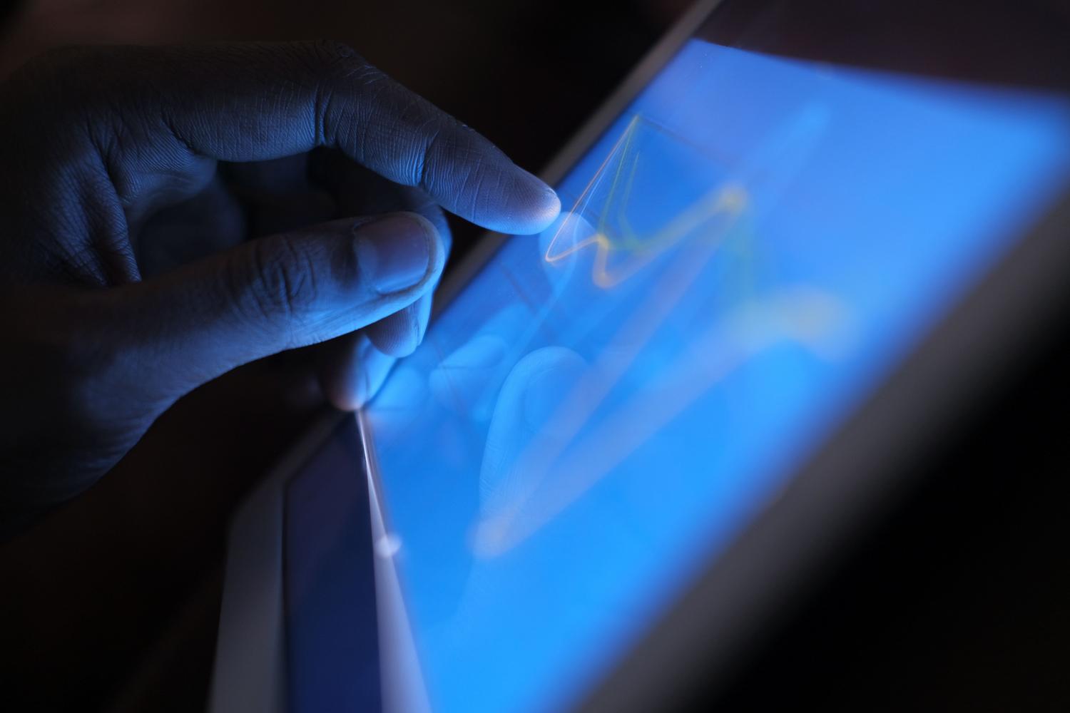 Mano interactuando con una tablet, ilustrando la compatibilidad del chip con dispositivos multimedia y pantallas 2K.