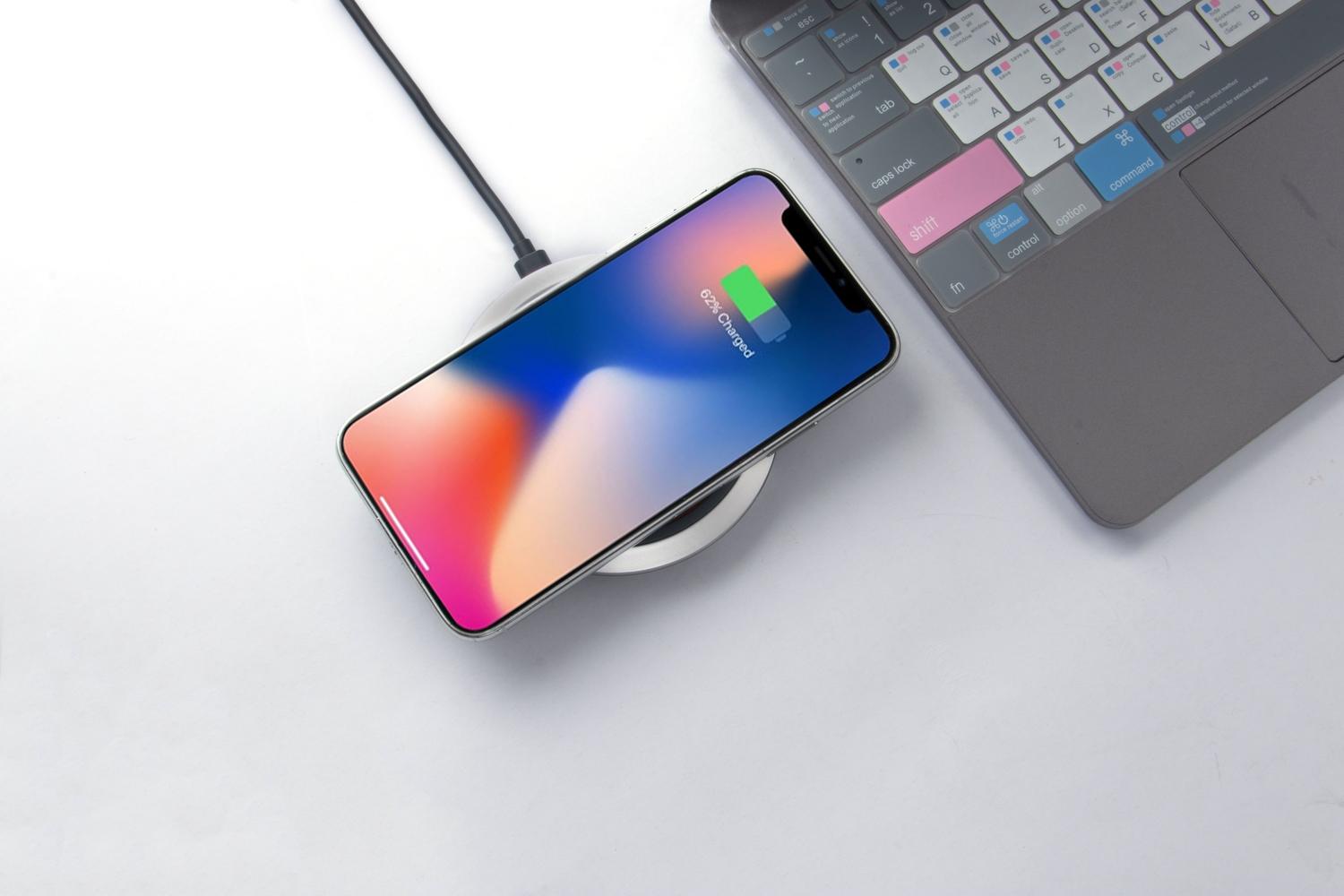 Smartphone cargando de forma inalámbrica sobre un escritorio, ilustrando los consejos de optimización de batería y carga.