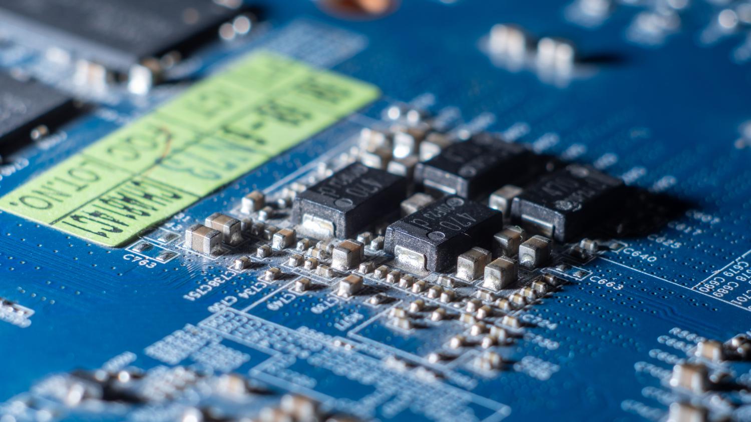Macro de una placa de circuito azul con múltiples microchips, ilustrando el ancho de banda y la densidad de datos