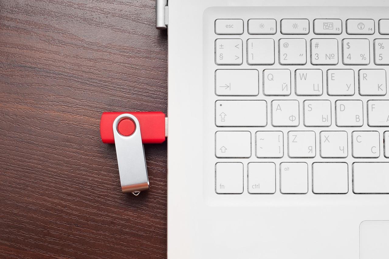 Memoria USB roja conectada a un portátil, representando el uso de sistemas operativos Live USB para mayor privacidad.