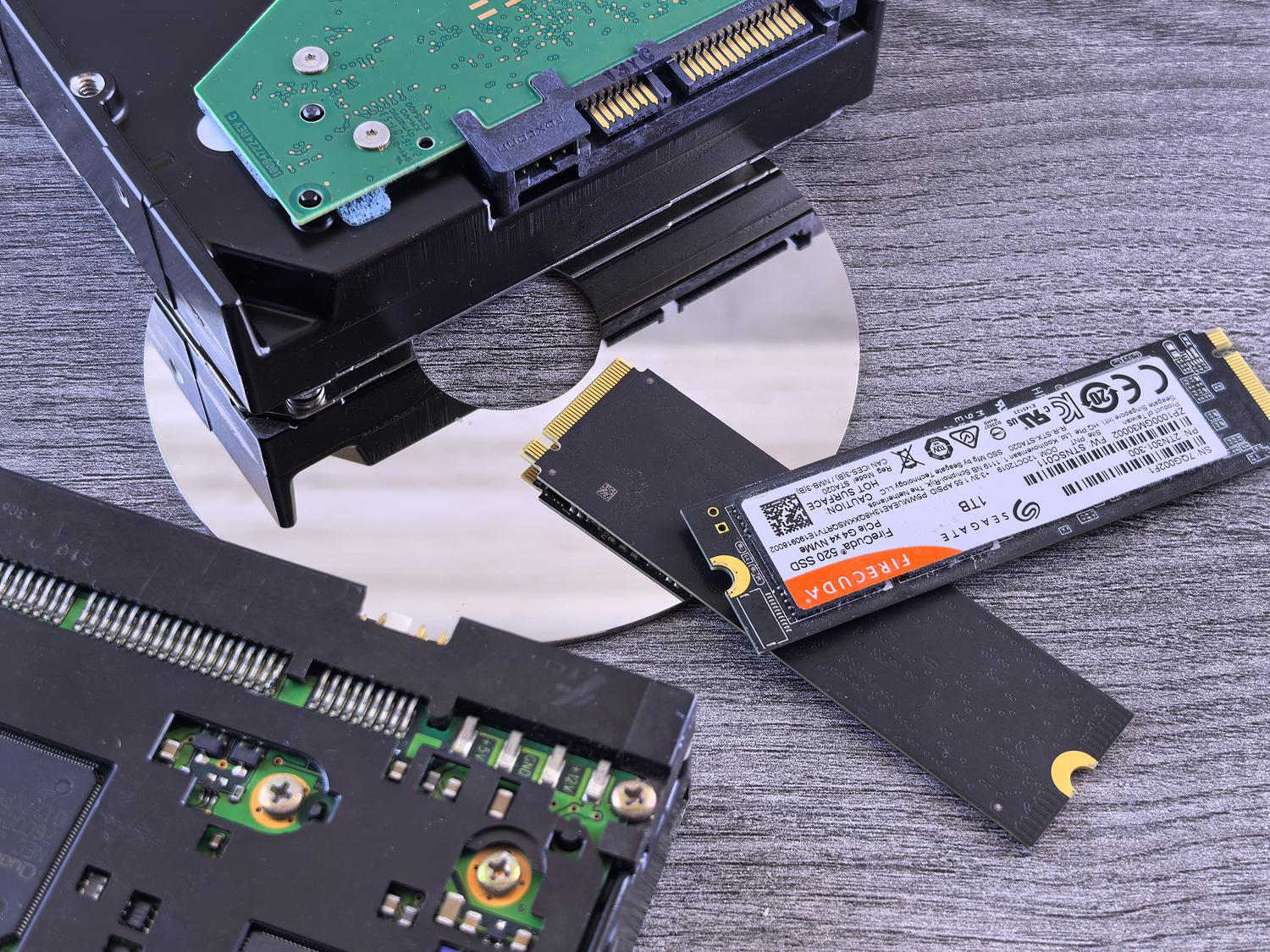 Diferentes tecnologías de almacenamiento de datos: SSD NVMe, HDD y CD.