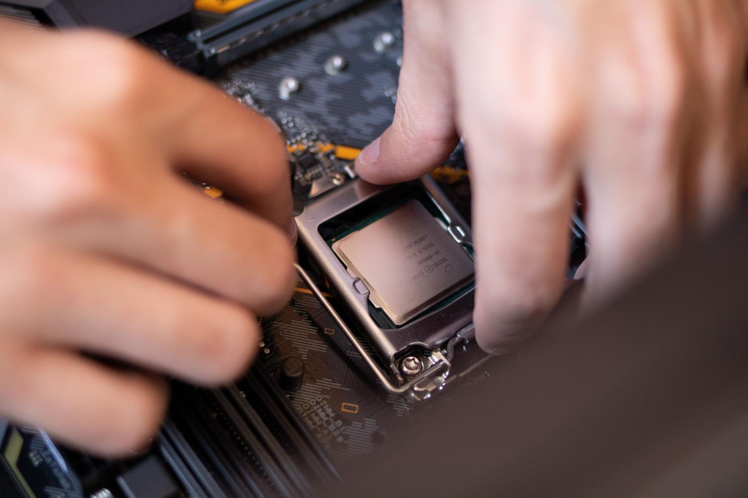 Close-up of hands installing a CPU into a motherboard, representing system maintenance and advanced hardware optimization.
