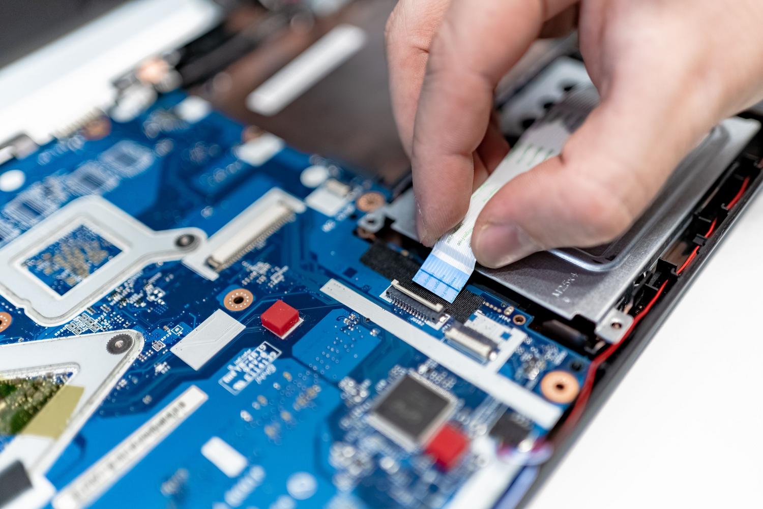 Reparación de cables flex en la placa base de un ordenador portátil.