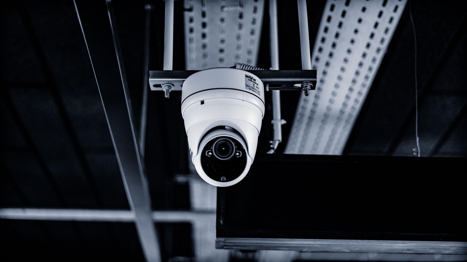Cámara de seguridad tipo domo instalada en un techo industrial, ideal para el monitoreo discreto de interiores.