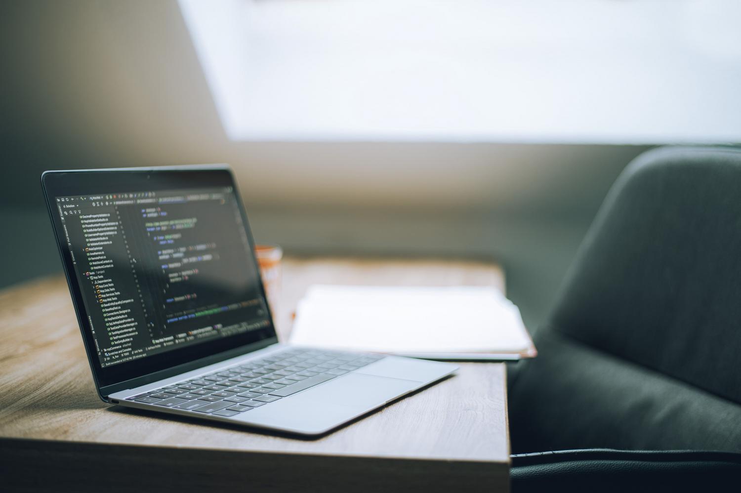 Portátil mostrando líneas de código en un escritorio moderno, representando la ejecución de comandos avanzados en CMD